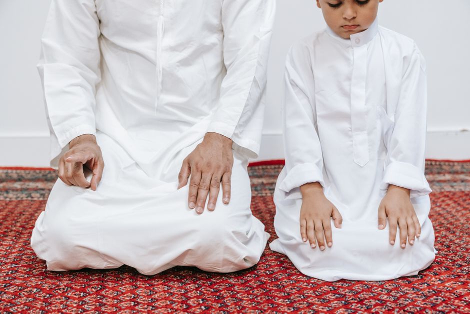 A parent and child kneeling together on the floor at home